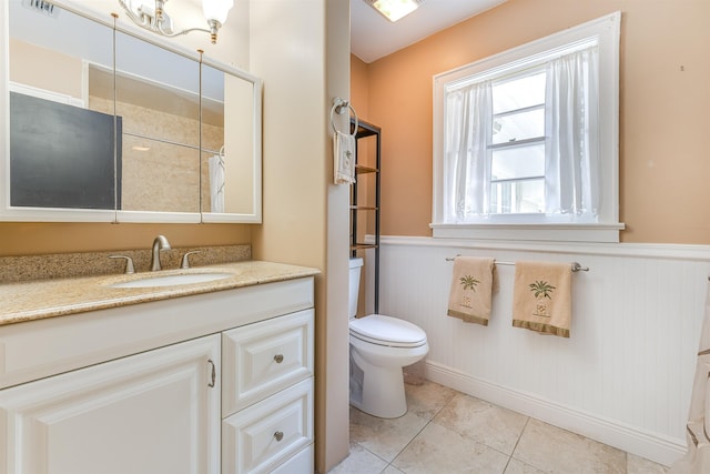 bathroom featuring toilet, vanity, wood walls, and tile patterned flooring