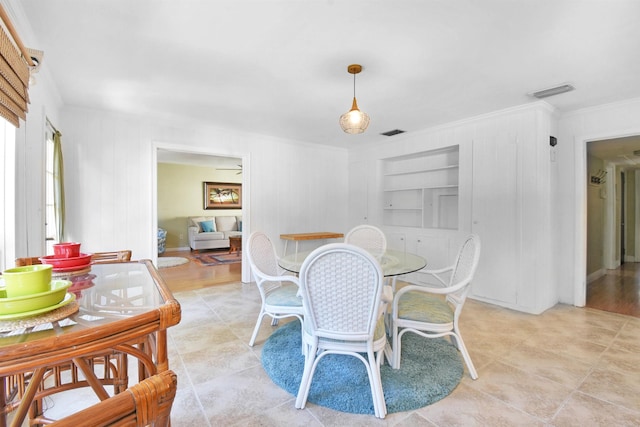 dining space featuring built in features and crown molding