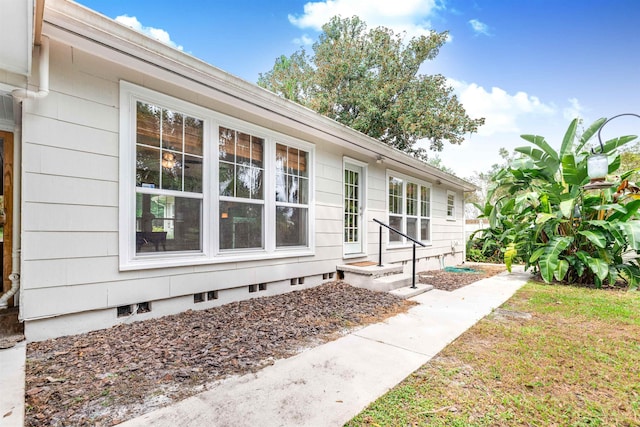 property entrance with a lawn