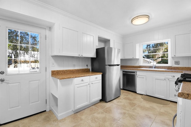 kitchen with white cabinets, sink, crown molding, and stainless steel appliances