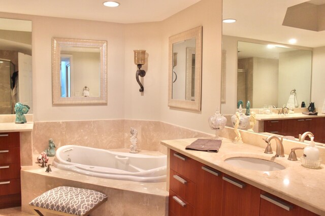 bathroom with vanity and a relaxing tiled tub