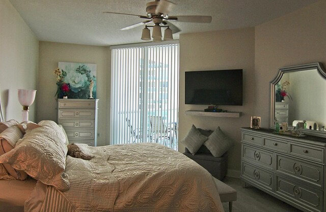 carpeted bedroom with access to exterior, a textured ceiling, and ceiling fan