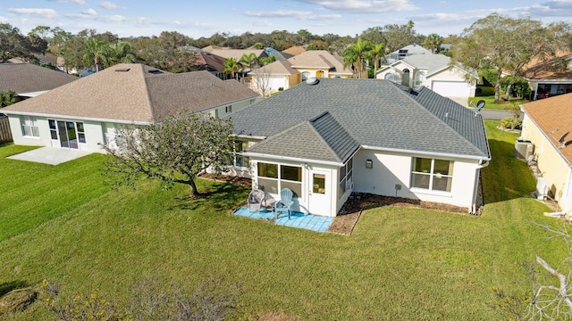 back of house featuring a patio area, a residential view, a yard, roof with shingles, and fence