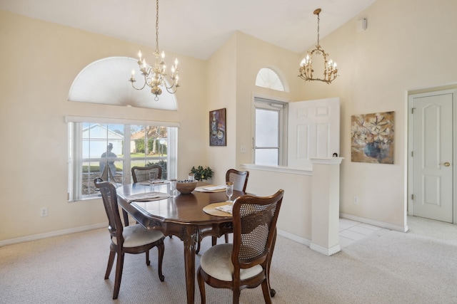 dining room featuring an inviting chandelier, light colored carpet, baseboards, and high vaulted ceiling