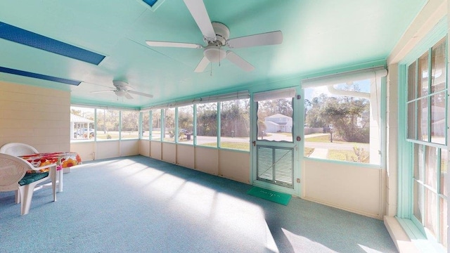 unfurnished sunroom with ceiling fan