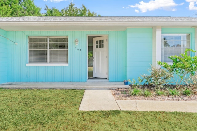 property entrance featuring a lawn