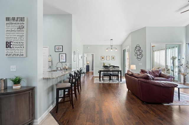 living room featuring lofted ceiling, dark hardwood / wood-style floors, and sink