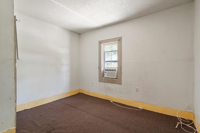 carpeted empty room featuring cooling unit and a textured ceiling