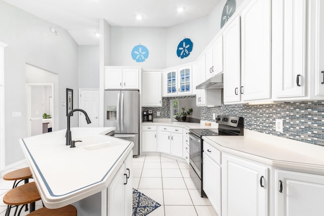 kitchen featuring appliances with stainless steel finishes, white cabinetry, sink, a kitchen bar, and a kitchen island with sink