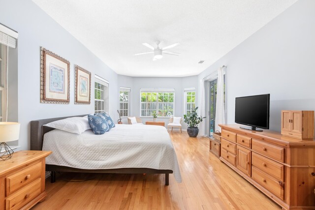 bedroom featuring access to outside, light hardwood / wood-style floors, and ceiling fan