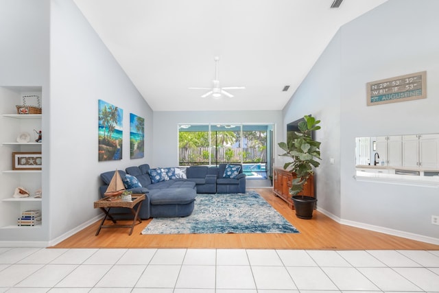 living room featuring sink, high vaulted ceiling, ceiling fan, and light tile patterned flooring