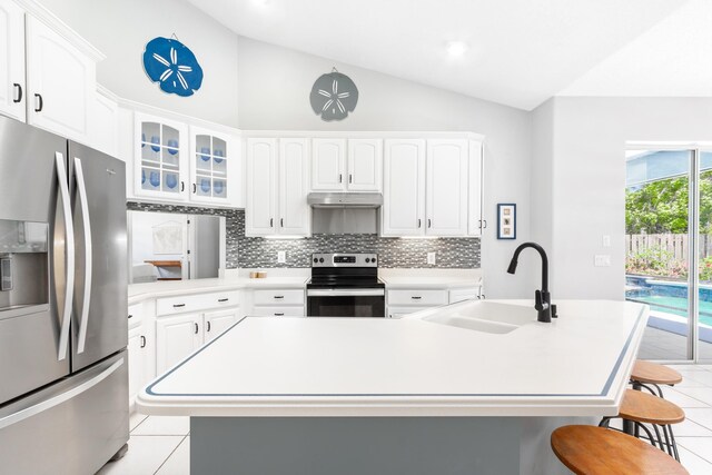 kitchen with sink, a breakfast bar, stainless steel appliances, white cabinets, and a center island with sink