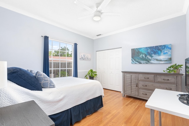 bedroom featuring light hardwood / wood-style flooring, ornamental molding, a closet, and ceiling fan