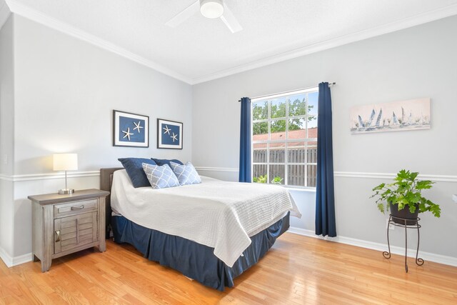 bedroom featuring hardwood / wood-style flooring, ceiling fan, and ornamental molding