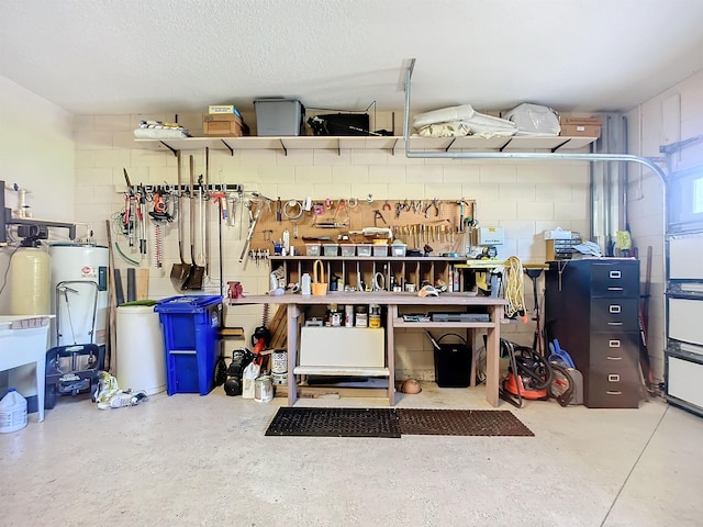 garage featuring a workshop area and water heater