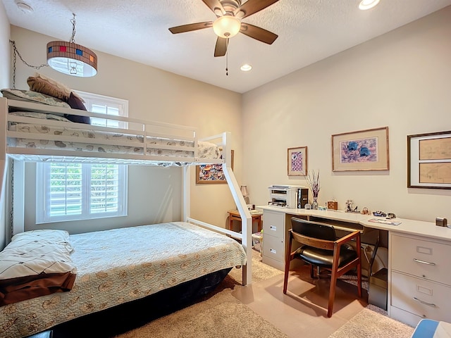 carpeted bedroom featuring ceiling fan and a textured ceiling