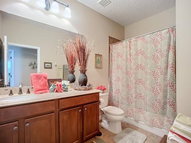 bathroom featuring vanity, tile patterned flooring, toilet, a textured ceiling, and walk in shower