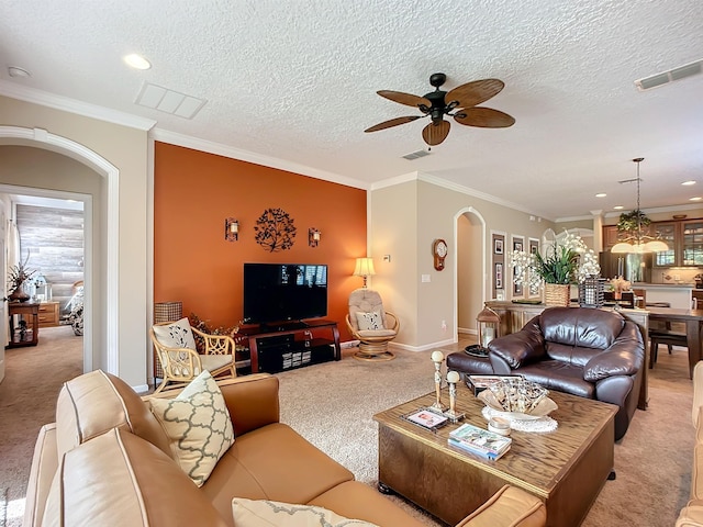 carpeted living room featuring a textured ceiling, ceiling fan, and crown molding