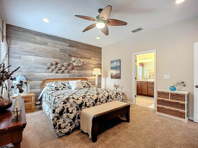 bedroom with light carpet, a textured ceiling, ceiling fan, and wooden walls