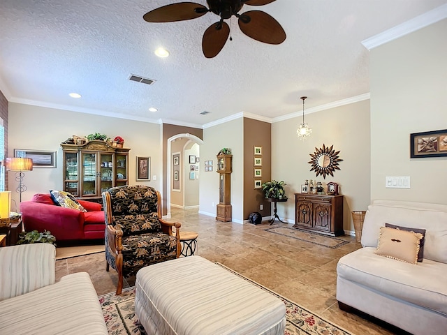 living room featuring ceiling fan, light tile patterned floors, a textured ceiling, and ornamental molding