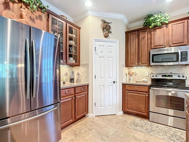 kitchen with backsplash, crown molding, a textured ceiling, light tile patterned floors, and appliances with stainless steel finishes