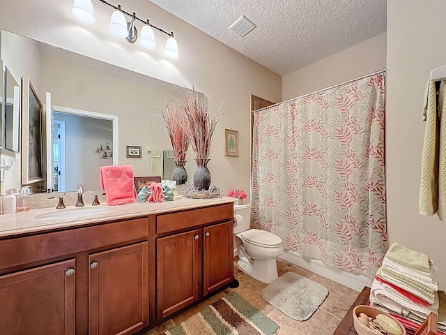 bathroom featuring vanity, a textured ceiling, toilet, and tile patterned flooring