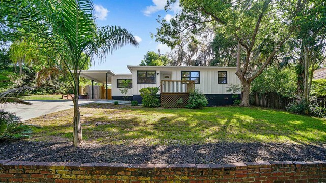 1403 S 15th St, Palatka, FL 32177 - view of front of property featuring a front yard, board and batten siding, fence, an attached carport, and driveway