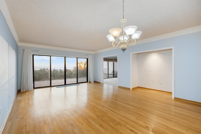 unfurnished room with light hardwood / wood-style floors, crown molding, and a notable chandelier