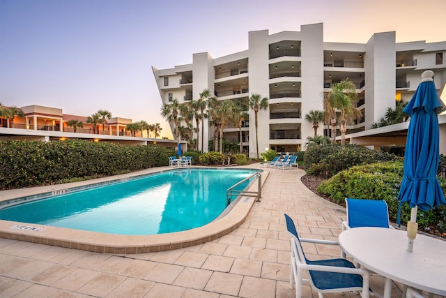 pool at dusk with a patio