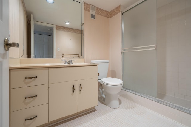 bathroom with tile patterned floors, vanity, toilet, and an enclosed shower