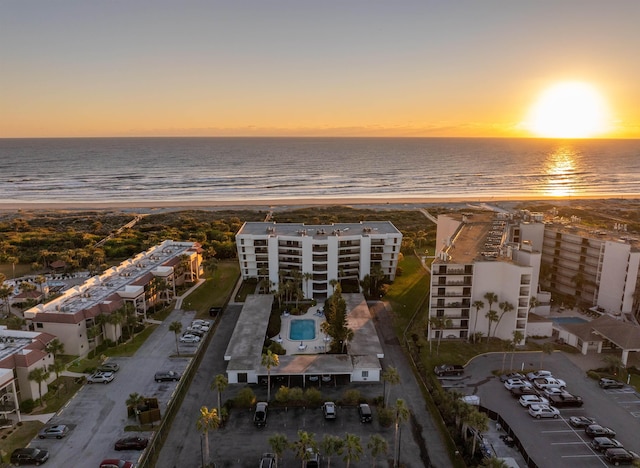 aerial view at dusk with a view of the beach and a water view