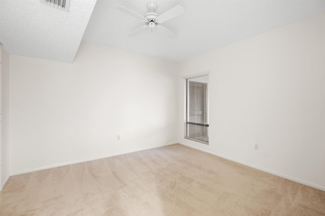 carpeted spare room with a textured ceiling and ceiling fan