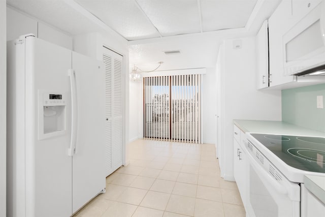 kitchen featuring white cabinets, white appliances, and light tile patterned floors