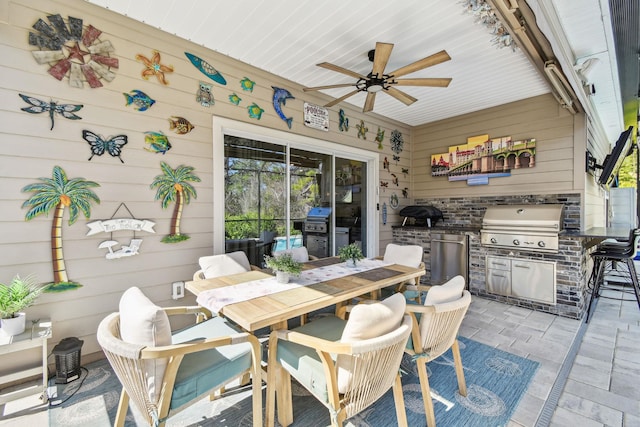 view of patio with a ceiling fan, outdoor dining area, area for grilling, and an outdoor kitchen