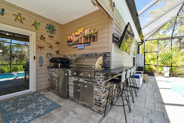 view of patio / terrace with glass enclosure, exterior kitchen, grilling area, an outdoor pool, and a bar