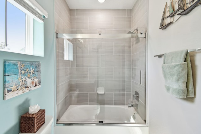 bathroom featuring bath / shower combo with glass door