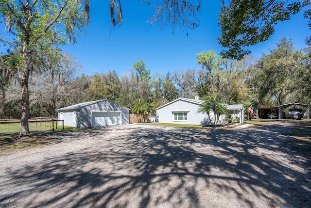 view of front of home featuring an outbuilding, a detached garage, and driveway