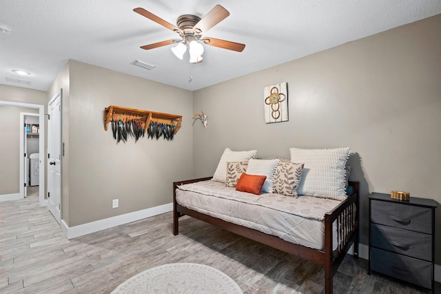 bedroom featuring baseboards, visible vents, and wood finished floors