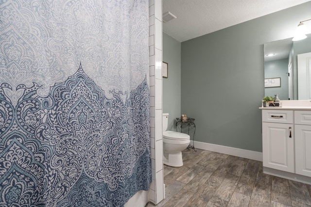 full bathroom with visible vents, toilet, a textured ceiling, wood finished floors, and baseboards