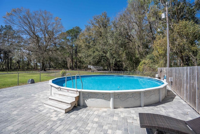 view of swimming pool featuring a patio area, fence, and a fenced in pool