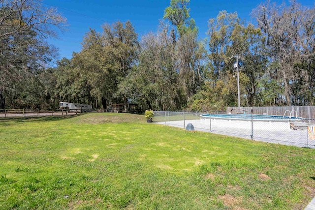 view of yard featuring fence and a fenced in pool