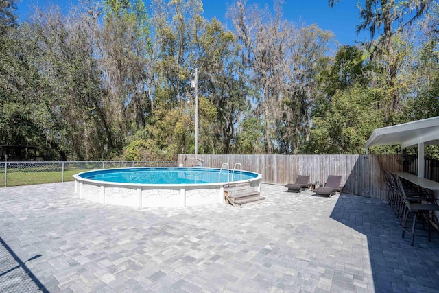 view of pool with a fenced in pool, a patio area, and a fenced backyard