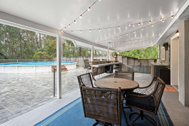 view of patio / terrace with outdoor dining area, a fenced backyard, and a fenced in pool