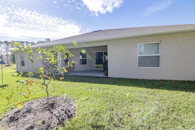 rear view of house featuring a lawn and a patio area