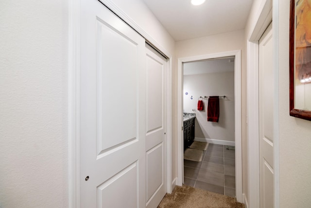 hall with tile patterned floors