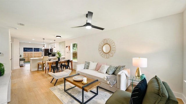 living room with light hardwood / wood-style flooring and ceiling fan