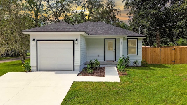 ranch-style house featuring a garage and a lawn