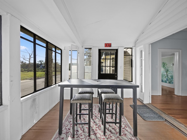 dining space featuring hardwood / wood-style flooring and vaulted ceiling