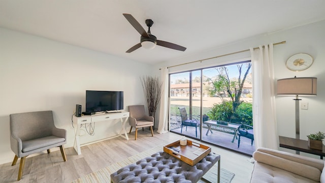 living room with ceiling fan and light hardwood / wood-style flooring