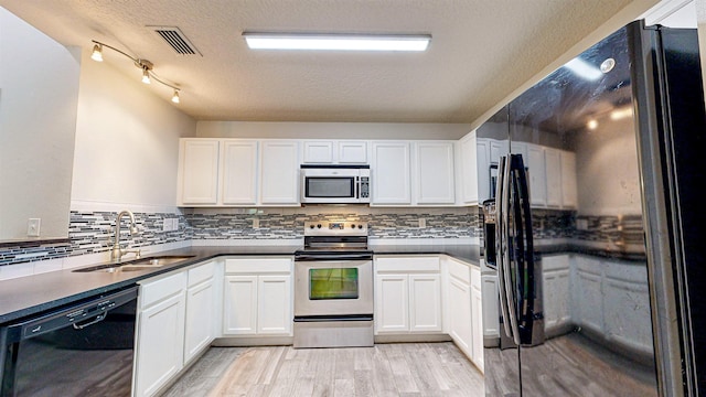 kitchen featuring black appliances, white cabinets, sink, light hardwood / wood-style flooring, and a textured ceiling